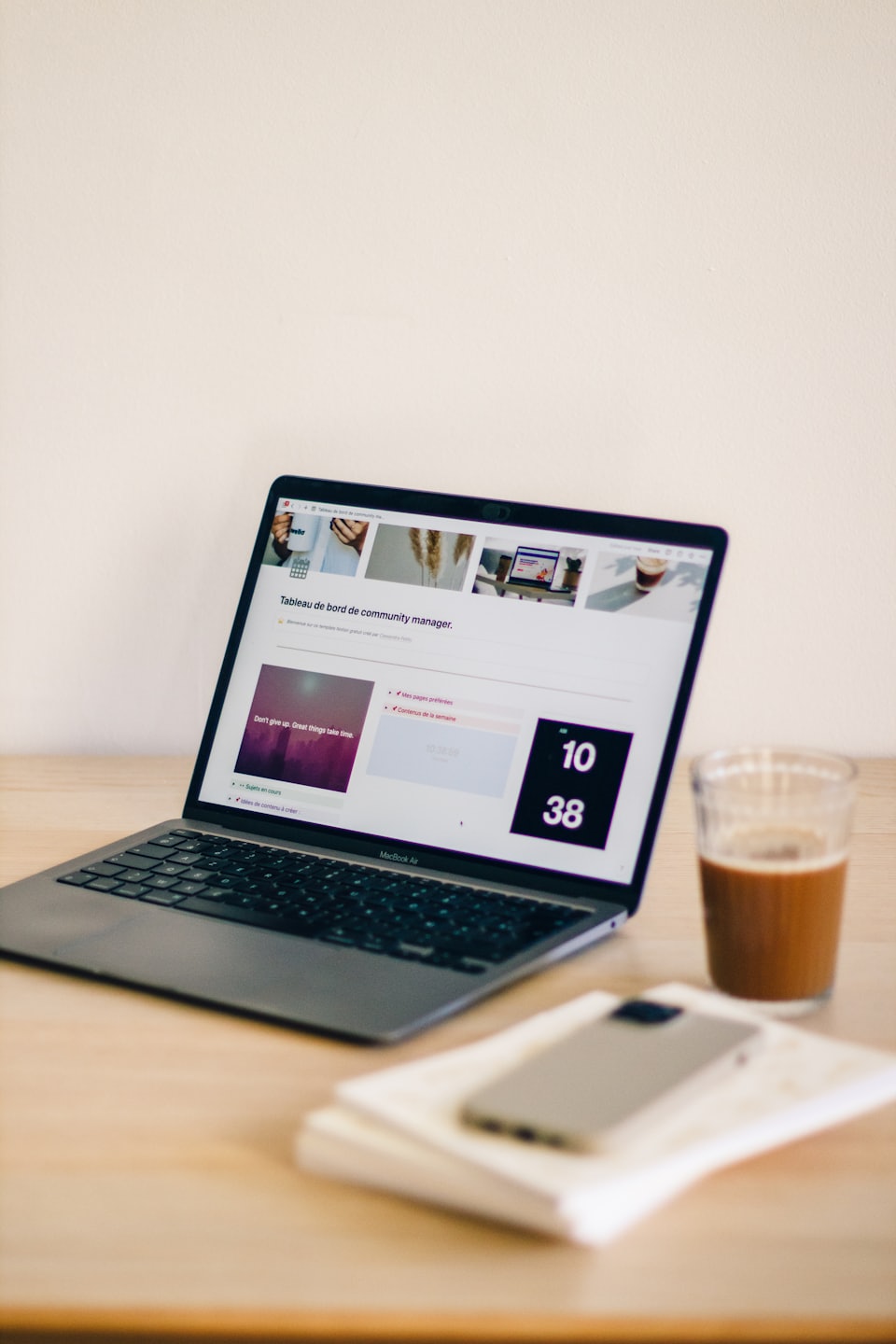 Laptop mit Dashboard auf einem Holztisch mit Eiskaffee.