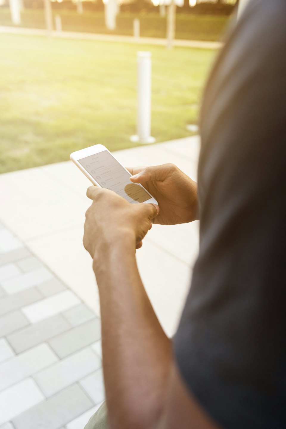 Eine Person benutzt im Freien ihr Smartphone in einer Messenger-App.
