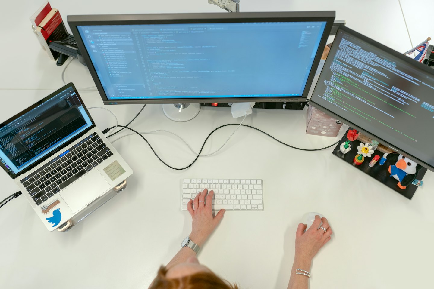 Entwickler programmiert an einem Arbeitsplatz mit mehreren Monitoren im Büro.