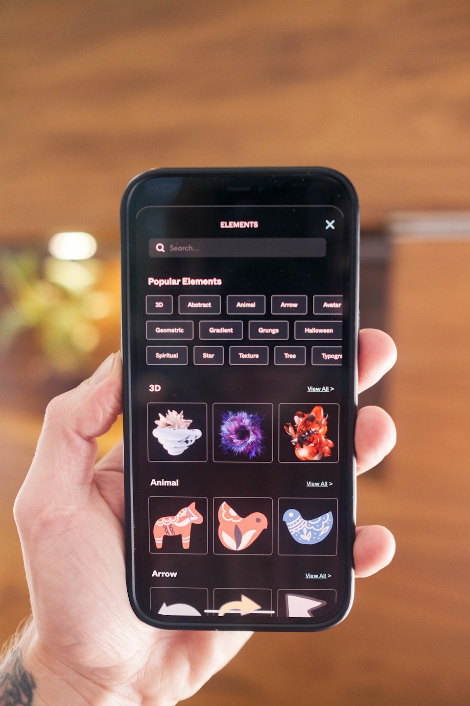 Eine Hand hält ein Smartphone mit einer Design-App.