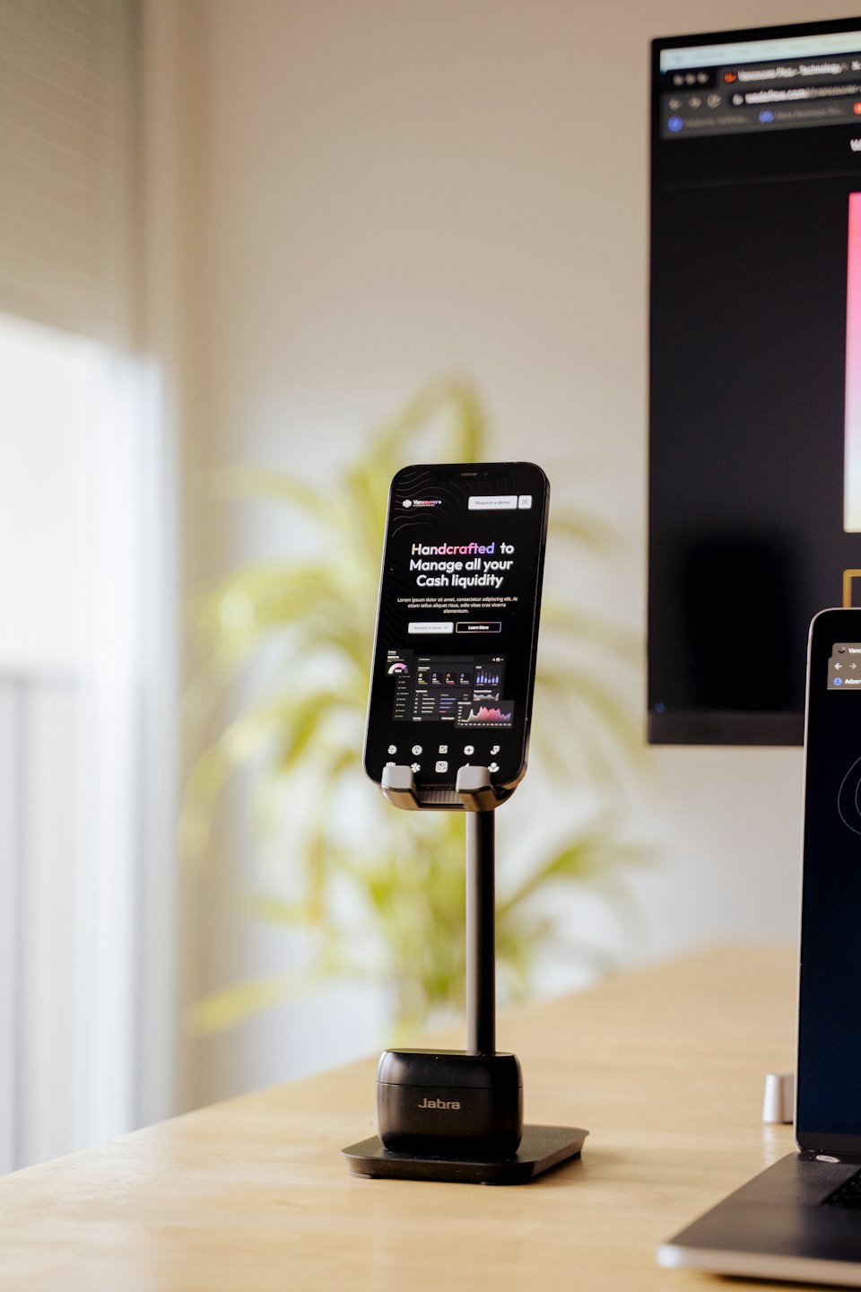 Smartphone auf einem Ständer mit Business-Dashboard auf einem Schreibtisch.