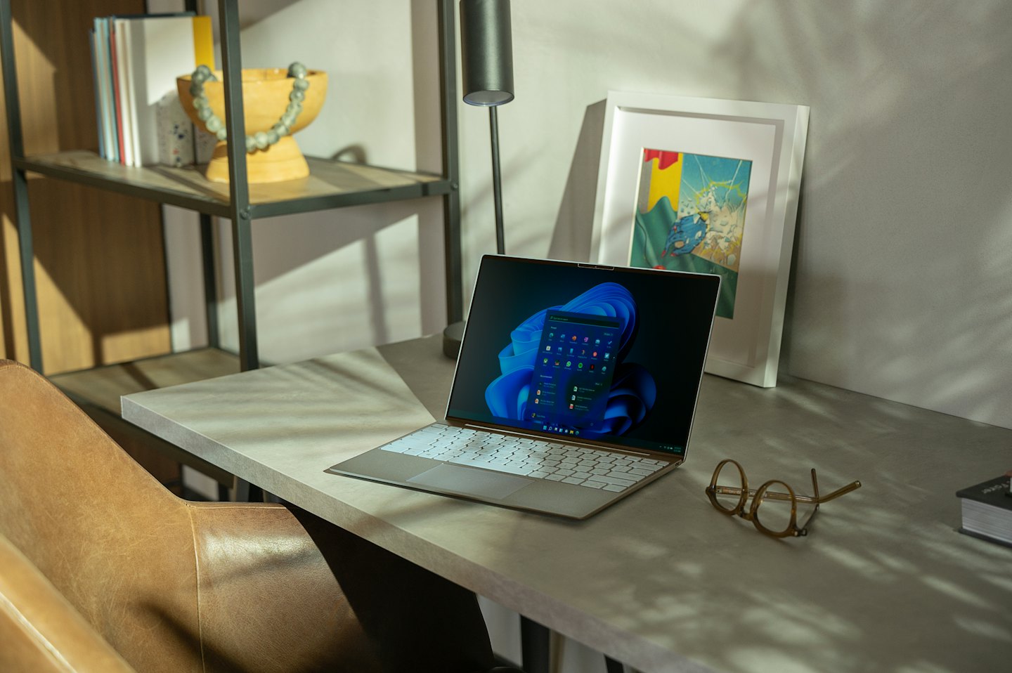 Silberner Laptop mit Windows-Betriebssystem auf einem Schreibtisch.